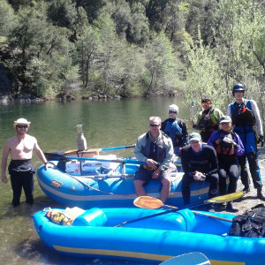 Image of a group sitting on a raft next to the upper sacramento river